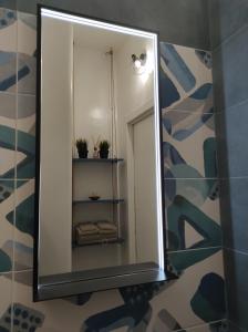einen Spiegel im Bad mit einem Regal mit Pflanzen in der Unterkunft Da Chloè in Monopoli