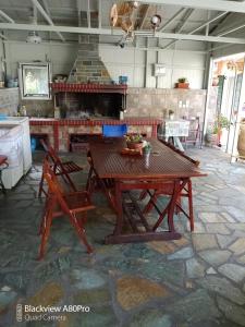 einen Holztisch und Stühle in einem Zimmer mit Kamin in der Unterkunft CHRYSPY Toulatos Studios in Pouláta