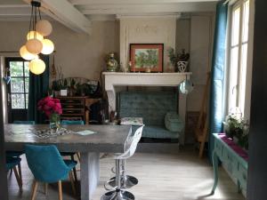 sala de estar con mesa y chimenea en Maison cosy à la campagne en Montpeyroux