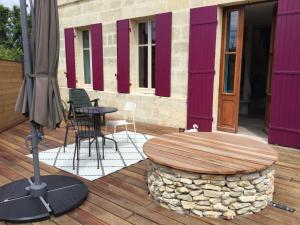 un patio con mesa, sillas y sombrilla en Maison cosy à la campagne en Montpeyroux