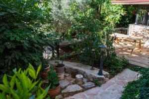 un jardín con un banco y algunas plantas en Harmony Inn en Safed