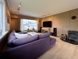 a living room with a purple couch and a tv at Midt i Lofoten in Alstad