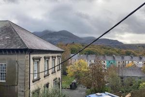 an old building in a town with mountains in the background at Ivy House in Bangor