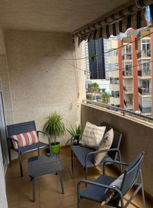 balkon z krzesłami, kanapą i oknami w obiekcie Apto Calpe con piscina. No uses coche vacaciones. w mieście Calpe +16 zdjęć