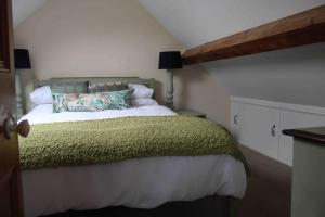 a bedroom with a bed with a green blanket at Ivy House in Bangor