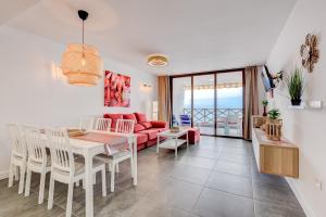 uma sala de jantar e sala de estar com um sofá vermelho em Neptuno 2A017 em Puerto de Santiago