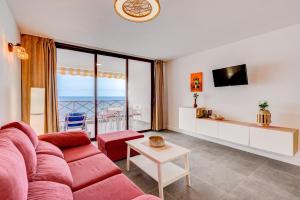 uma sala de estar com um sofá vermelho e uma mesa em Neptuno 2A017 em Puerto de Santiago