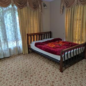 1 dormitorio con 1 cama con edredón rojo en New urban Den cottage en Srinagar