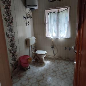 a bathroom with a toilet and a window at New urban Den cottage in Srinagar