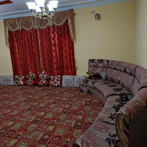 a living room with a couch and a red curtain at New urban Den cottage in Srinagar
