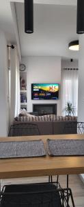 a living room with a table and a tv at Central Park Apartment in Volos