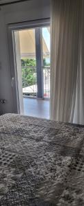 a bedroom with a bed and a sliding glass door at Central Park Apartment in Volos