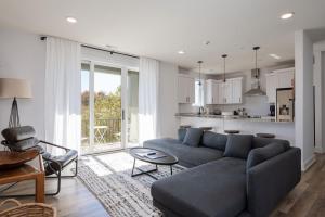 a living room with a blue couch and a kitchen at Piedmont Place Suite 402 Modern Apartment in Heart of Crozet in Crozet