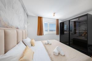 1 dormitorio con 1 cama con toallas en Penthouse Apartments East and West Star, en Kaštela