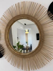a large round mirror with a rattan frame on a wall at Casa AMARE - Naxos in Naxos Chora