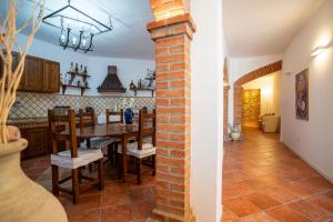 una cucina e una sala da pranzo con pilastro in mattoni di Casa del Sole a Belvedere Marittimo
