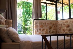 a bedroom with a bed and a large window at Harmony Inn in Safed