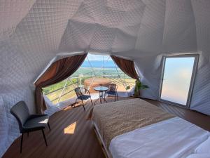 a bedroom with a bed and a large window at Signagi Glamping in Sighnaghi