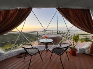 a room with a table and chairs on a balcony at Signagi Glamping in Sighnaghi