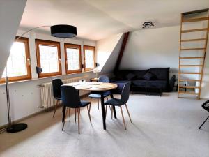 a living room with a table and chairs and a couch at Calma Apartment in Weimar +34 photos