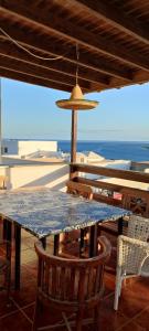 une table bleue avec des chaises et un parasol et l'océan dans l'établissement ANCONES LEJANOS GuestHouse, à Costa Teguise