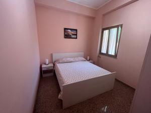 Un dormitorio pequeño con una cama y una ventana. en Caccia Apartment, en Santa Teresa di Riva