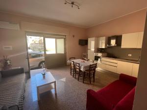 una sala de estar con un sofá y una mesa en Caccia Apartment, en Santa Teresa di Riva