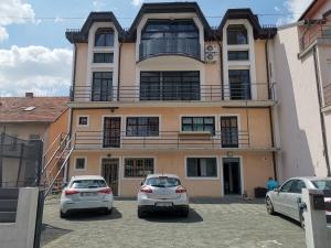 two cars parked in a parking lot in front of a building at Apartmani Dubrava 3 in Zagreb