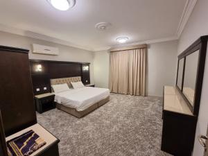 Habitación de hotel con cama y TV en عنوانك للشقق المخدومة en Abha