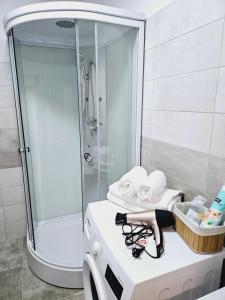 a bathroom with a shower and a woman laying on a stool at Comapart in Bacău