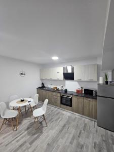 a kitchen with white cabinets and a table and chairs at Comapart in Bacău