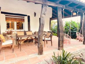 un patio con mesa de madera y sillas en Yin Yang Beach House, El Palmar, con WIFI a 500 m de la playa en Cádiz