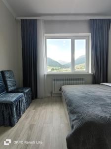 1 dormitorio con 1 cama, 1 silla y 1 ventana en Hotel Kolsay Eki Agayindy, en Kurmenty