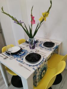 a table with two plates and a vase of flowers at Iris's apartament in Sinaia +8 photos