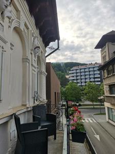 a balcony with chairs and flowers on a building at Iris's apartament in Sinaia