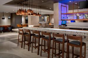a bar in a restaurant with chairs and a counter at New York LaGuardia Airport Marriott in Queens