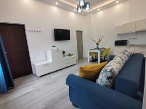 a living room with a blue couch and a tv at Iris's apartament in Sinaia