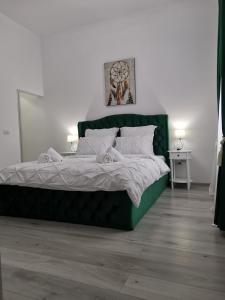 a large green bed in a white room with at Iris's apartament in Sinaia