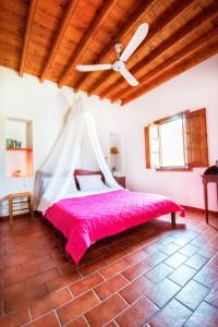 a bedroom with a bed with a ceiling fan at Siroco Patmos Agriolivadi in Patmos