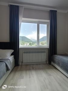 ein Schlafzimmer mit einem großen Fenster mit einem Bett und einem Heizkörper in der Unterkunft Hotel Kolsay Eki Agayindy in Kurmenty