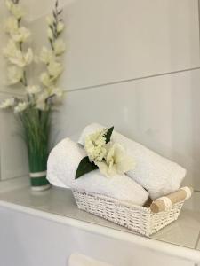 a basket of towels on a shelf with a vase of flowers at FeWo im Harz in Bad Harzburg