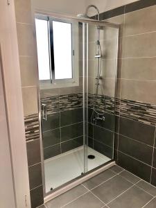 La salle de bains est pourvue d'une douche avec une porte en verre. dans l'établissement APARTENERIFE, à La Laguna