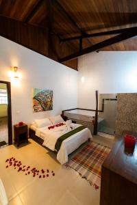 a bedroom with a bed with red flowers on the floor at Pousada Verde Folhas in Casa Branca