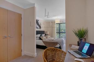 een slaapkamer met een bed en een bureau met een laptop bij Lyter Living-The Foundry-Jericho-Oxford-Parking Included in Oxford