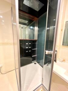 a shower with a glass door in a bathroom at Kuat house in Almaty