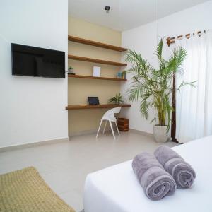 Habitación con cama, escritorio y TV. en Enigmatic Hotel Experience en Cancún