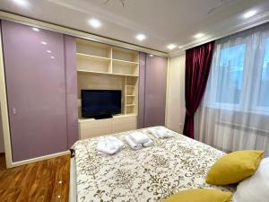 a bedroom with a bed with towels on it at Kuat house in Almaty
