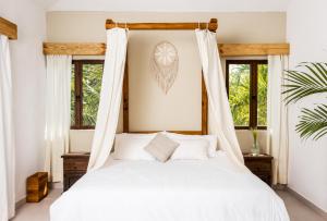 1 dormitorio con 1 cama con sábanas blancas y ventanas en Enigmatic Hotel Experience en Cancún