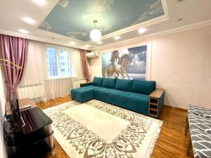 a living room with a blue couch and a painting of a horse at Kuat house in Almaty