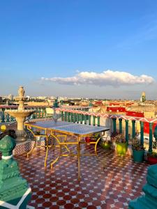a table on a roof with a view of a city at Riad Malak in Meknès